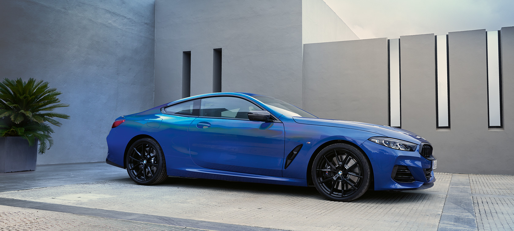 BMW 8 Series Coupé G15 LCI Facelift 2022 M Portimao Blue metallic Side view standing in front of house wall