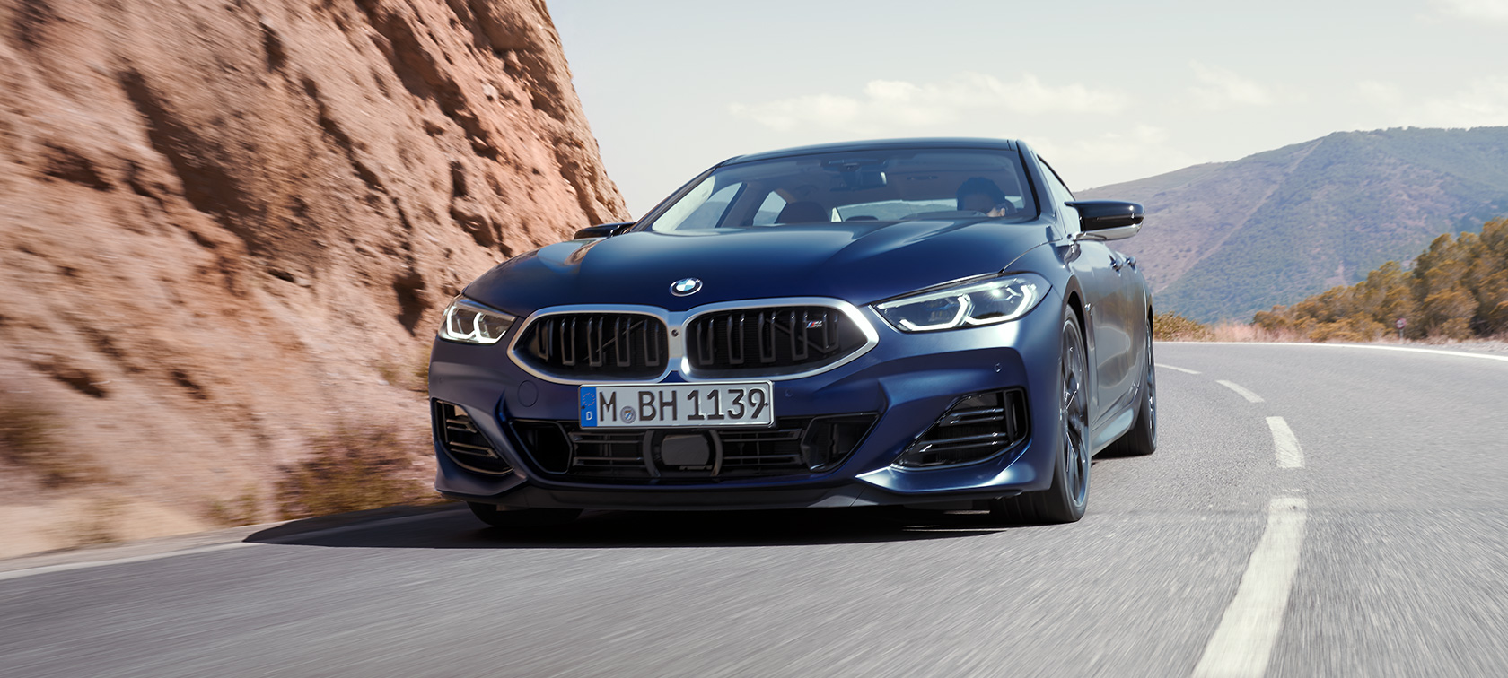 BMW M850i xDrive Gran Coupé G16 LCI Facelift 2022 BMW Individual Frozen Tanzanite Blue metallic three-quarter front view driving through the bend