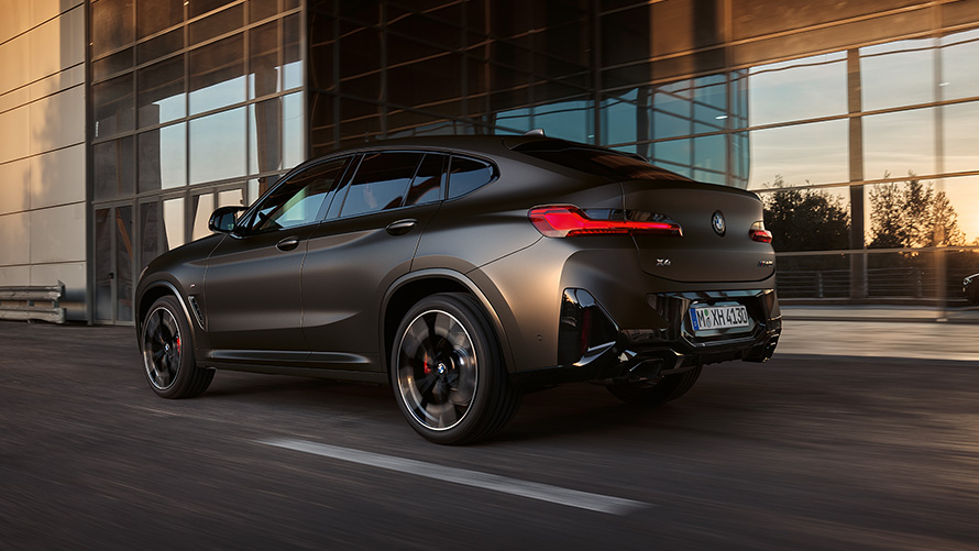 BMW X4 M40i G02 LCI 2021 Facelift three-quarter rear view in front of glass facade