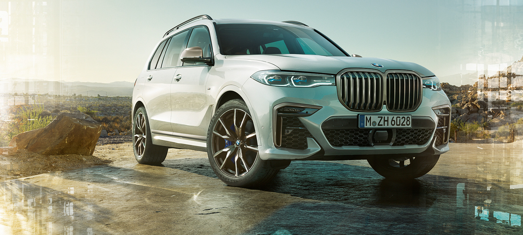 BMW X7 M50i in Mineral White, driving on an empty highway, rear view, G07, 2019